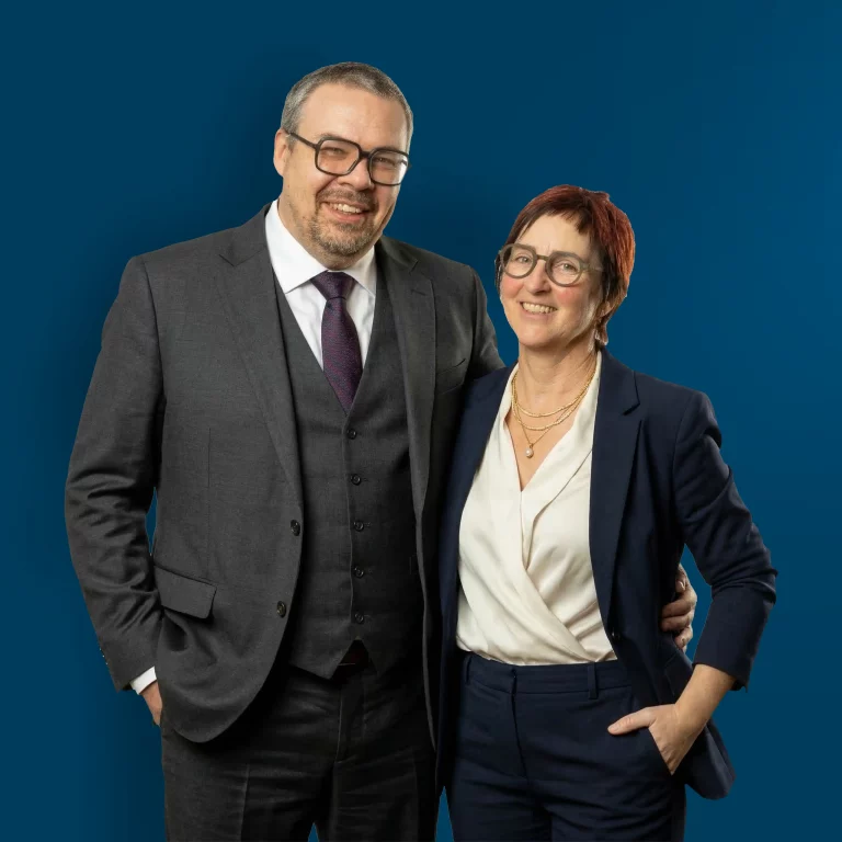 Das Inhaber Michael Schweinberger mit seiner Frau Ruth Schweinberger von Schweinberger Glasfaser Experte steht gemeinsam vor einem einheitlich blauen Hintergrund.