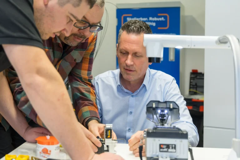 Praxisnahe Glasfaser-Schulung – Trainer erklärt Teilnehmern Spleißtechnik und Geräte im Workshop zum Breitbandausbau.